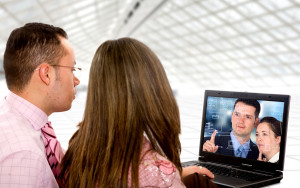 business couple on a laptop in an office environment watching a trainning video